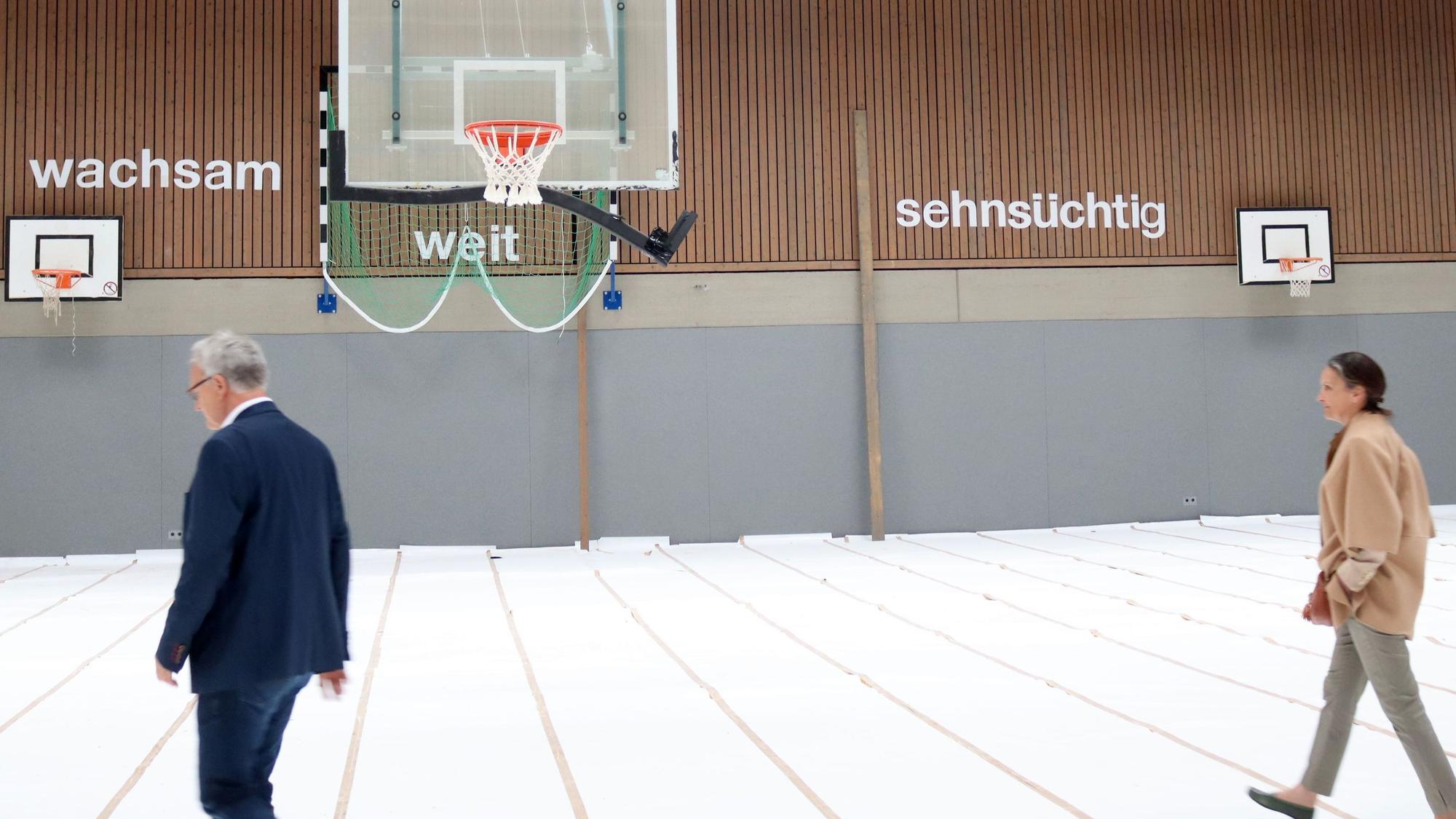 Bernhard Helfer führt eine Delegation durch die Sporthalle.