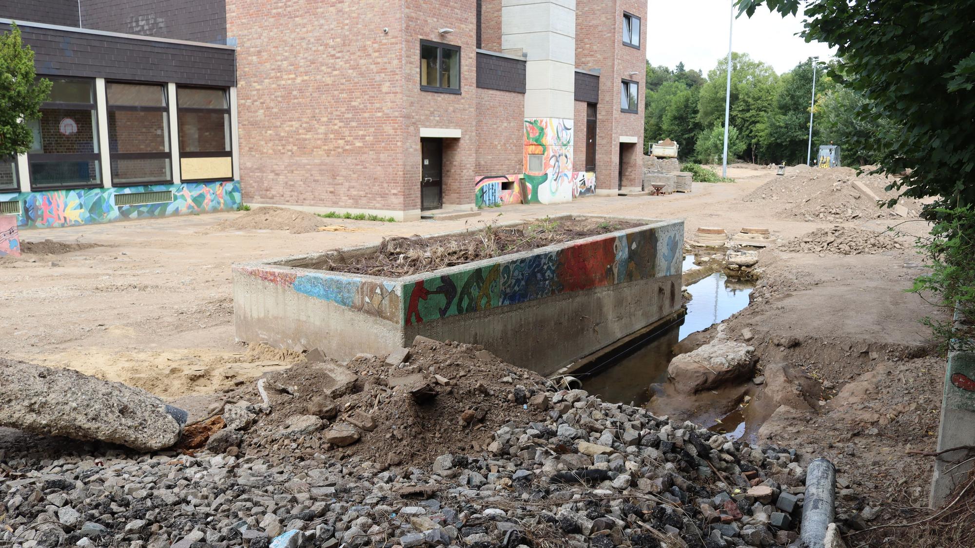 Das Bild, aufgenommen einen Monat nach der Flut, zeigt den stark beschädigten Schulhof.