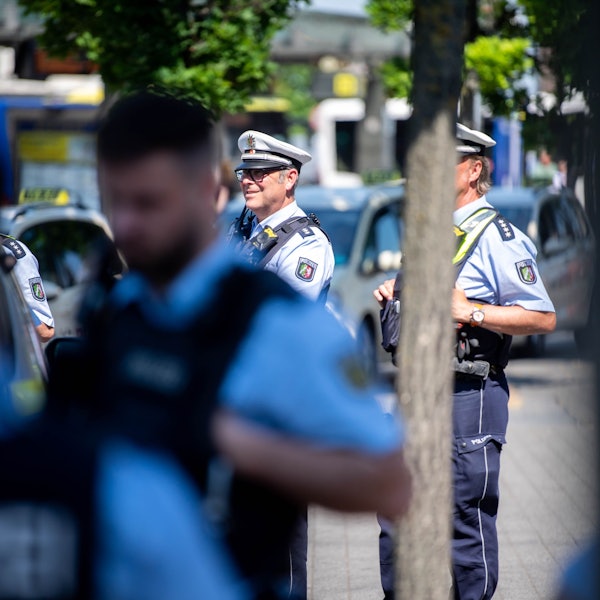 Drei Polizisten beobachten das Geschehen auf dem Vorplatz des Euskirchener Bahnhofs.
