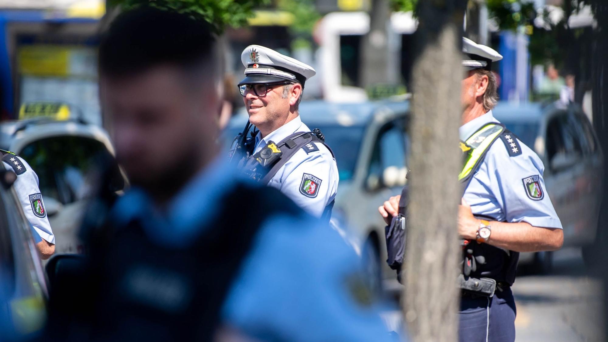 Drei Polizisten beobachten das Geschehen auf dem Vorplatz des Euskirchener Bahnhofs.