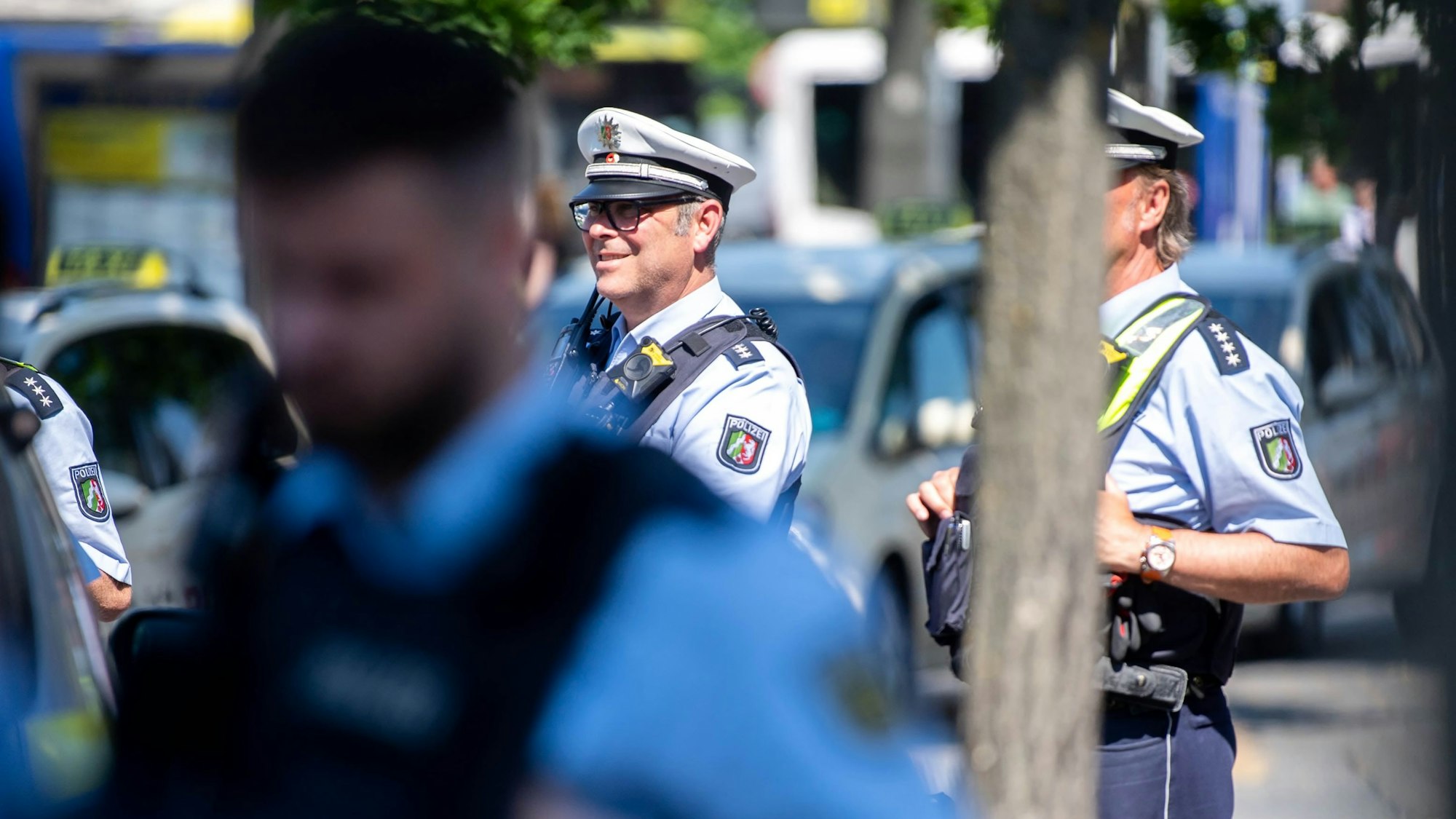 Drei Polizisten beobachten das Geschehen auf dem Vorplatz des Euskirchener Bahnhofs.