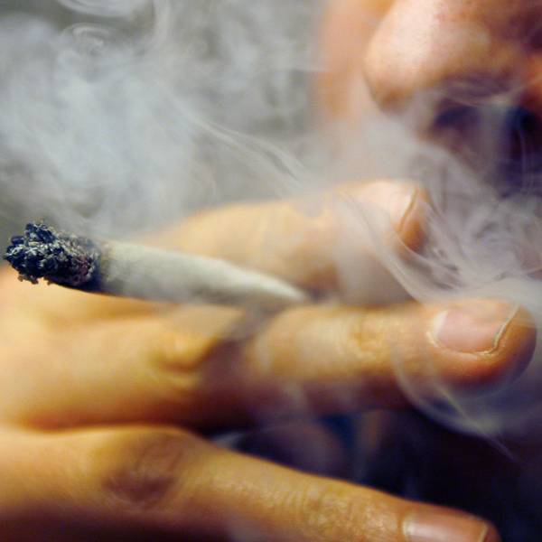 Ein Mann raucht einen Joint mit Marihuana.