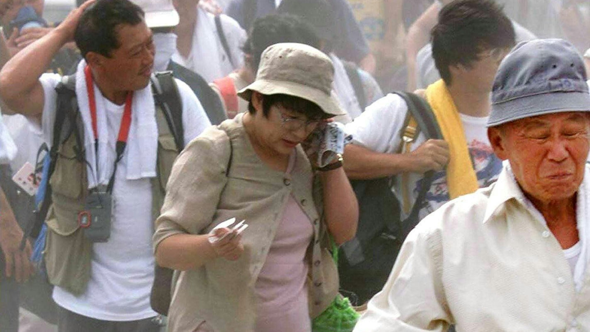 Bewohner der japanischen Insel Miyake-jima, 150 km südlich von Tokio, gehen am 31. August 2000 durch Vulkanasche zu einer Fähre, die sie von der Insel evakuieren soll, während der Vulkan Mount Oyama weiter bebt.