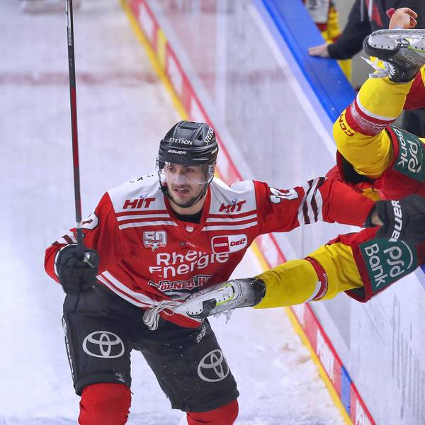 Maximilian Glötzl von Kölner Haie schickt Josef Eham von Düsseldorfer EG über die Bande vom Spielfeld auf die Spielerbank.