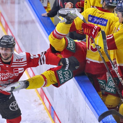 Maximilian Glötzl von Kölner Haie schickt Josef Eham von Düsseldorfer EG über die Bande vom Spielfeld auf die Spielerbank.