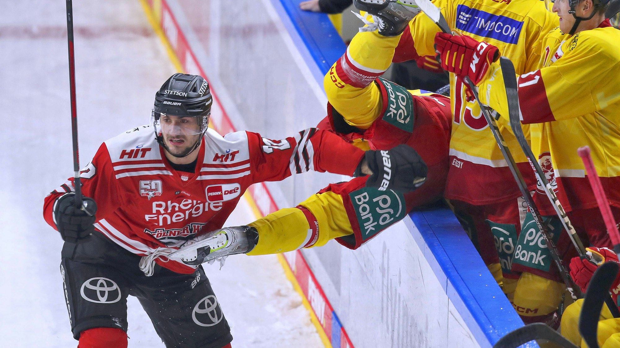 Maximilian Glötzl von Kölner Haie schickt Josef Eham von Düsseldorfer EG über die Bande vom Spielfeld auf die Spielerbank.
