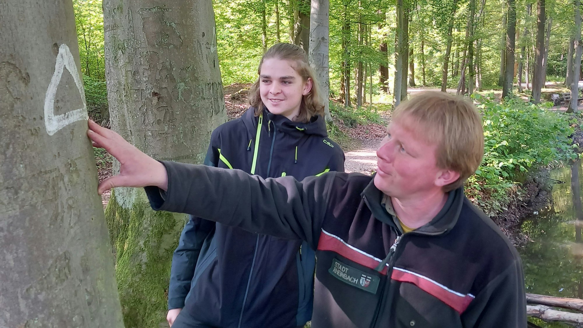 Forstamt Rheinbach markiert Bäume mit weißem Dreieck. Förster Sebastian Tölle (41) mit Tagespraktikant Patrick Bohnhoff (17)