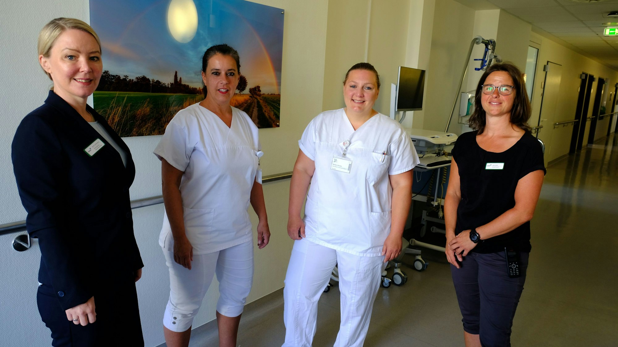 Vier Mitarbeiterinnen, davon zwei Pflegekräfte, in einem Flur des Mechernicher Krankenhauses.