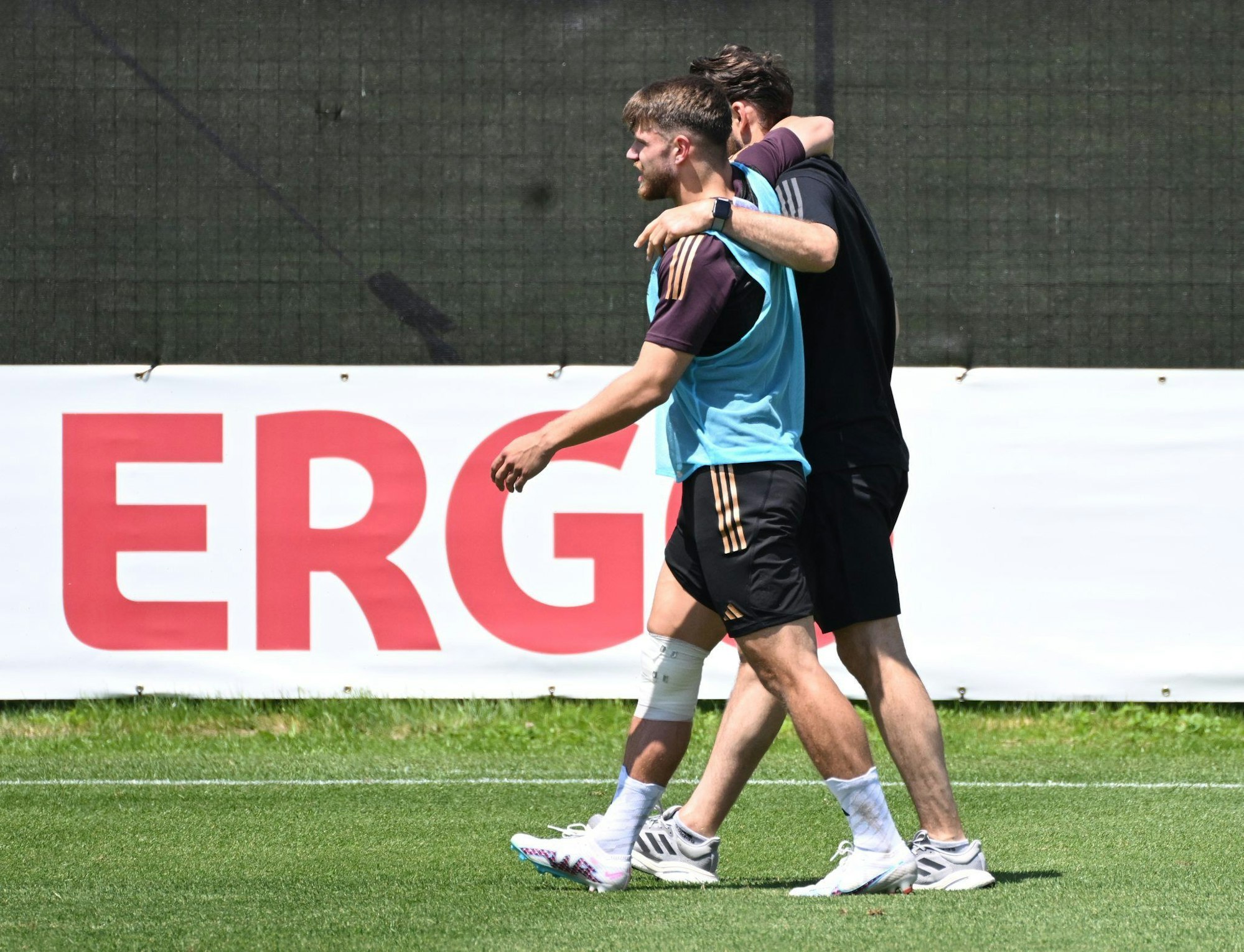 U21-Nationalspieler Jan Thielmann vom 1. FC Köln verlässt von einem Betreuer gestützt und am Knie bandagiert den Trainingsplatz im italienischen Prad. dpa-Bildfunk +++