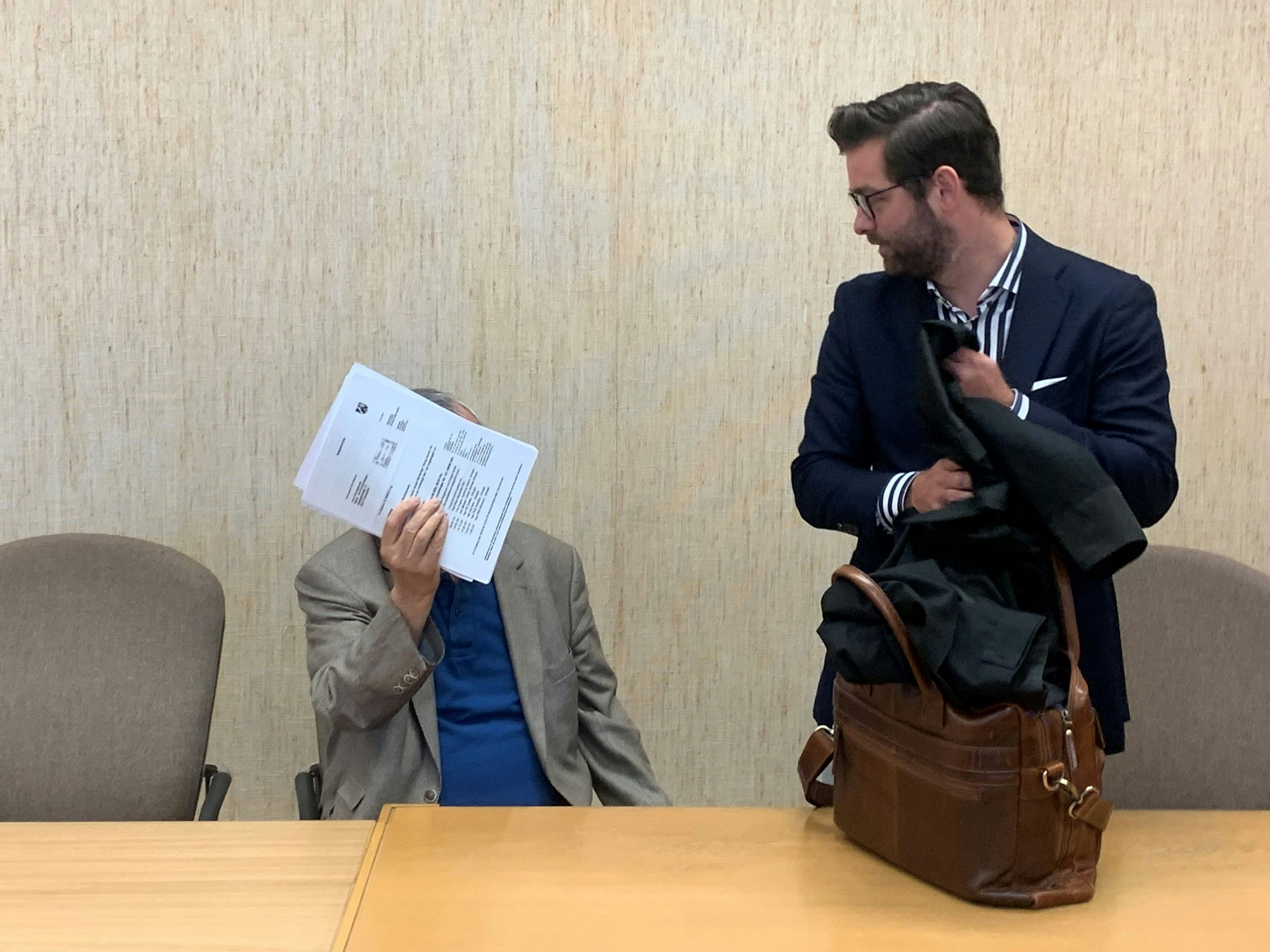 Der Angeklagte verdeckte sein Gesicht vor den Fotografen im Gerichtssaal.