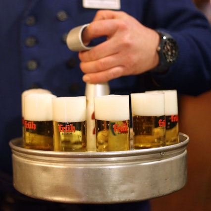 Ein Köbes (Kellner) trägt im Brauhaus Früh am Dom Kölsch-Bier aus.