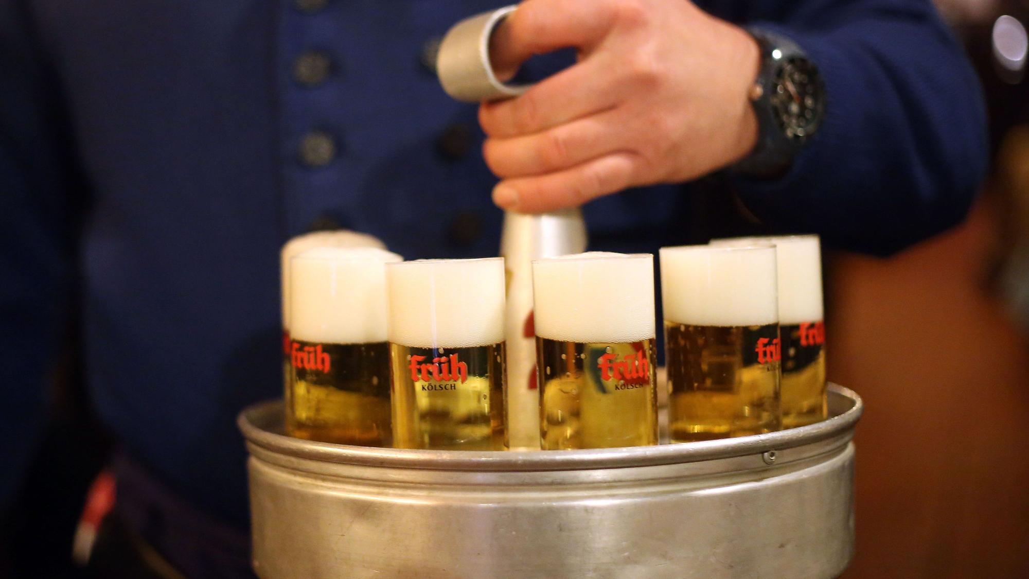 Ein Köbes mit einem Kranz Kölsch (Symbolbild).