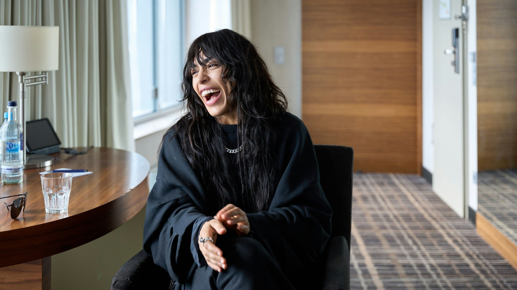 Loreen sitzt in einem Hotelzimmer auf einem Stuhl.