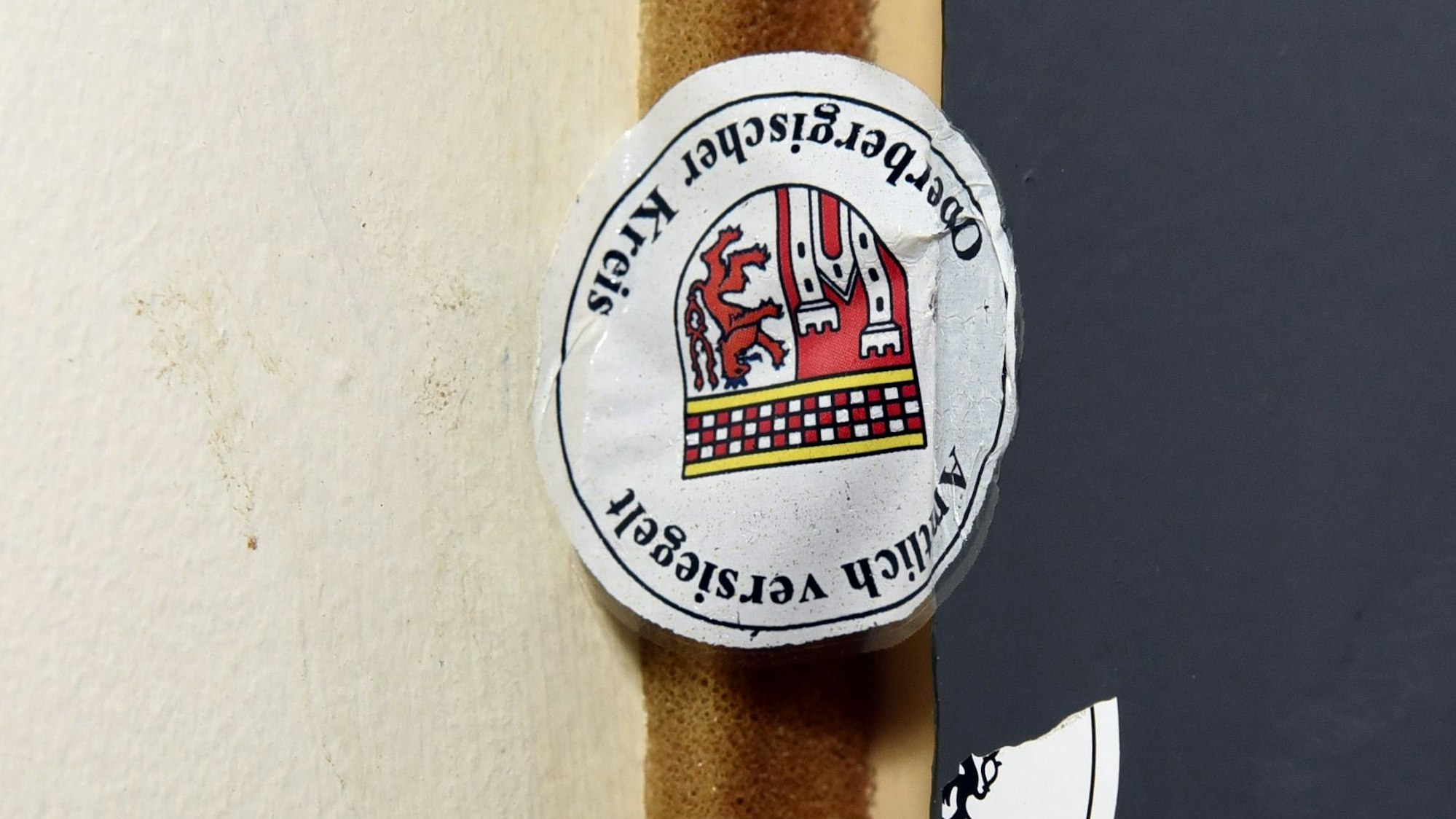 Ein Siegel mit dem Wappen des Oberbergischen Kreises an einer Tür.