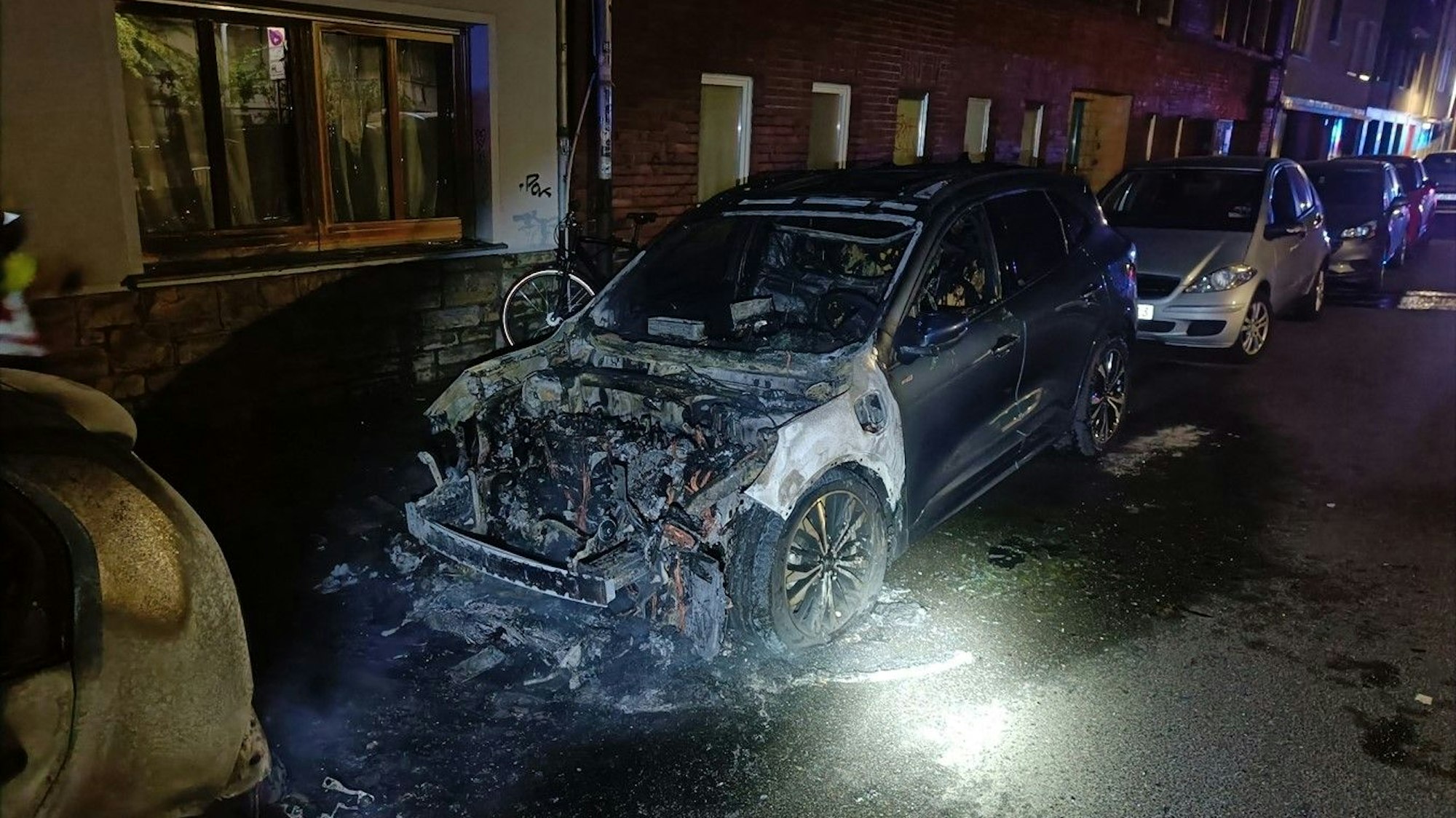 Ausgebranntes Auto in Aachen: Die Polizei sucht einen Serien-Brandstifter.