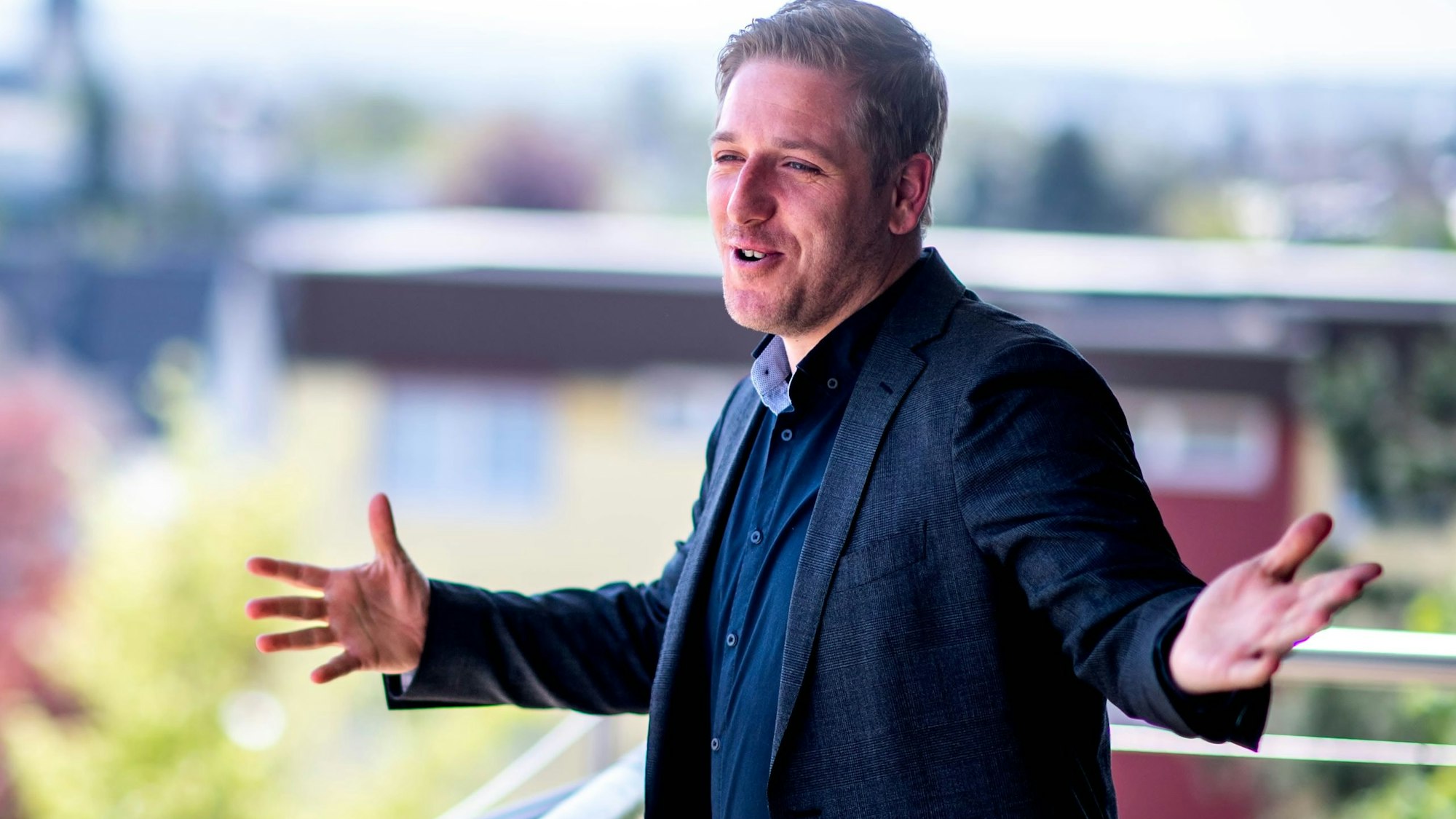 Euskirchens Landrat Markus Ramers steht auf dem Balkon am Kreishaus und breitet die Arme aus.