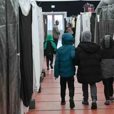 Flüchtlingskinder gehen durch ein Zelt der Flüchtlingsunterkunft.