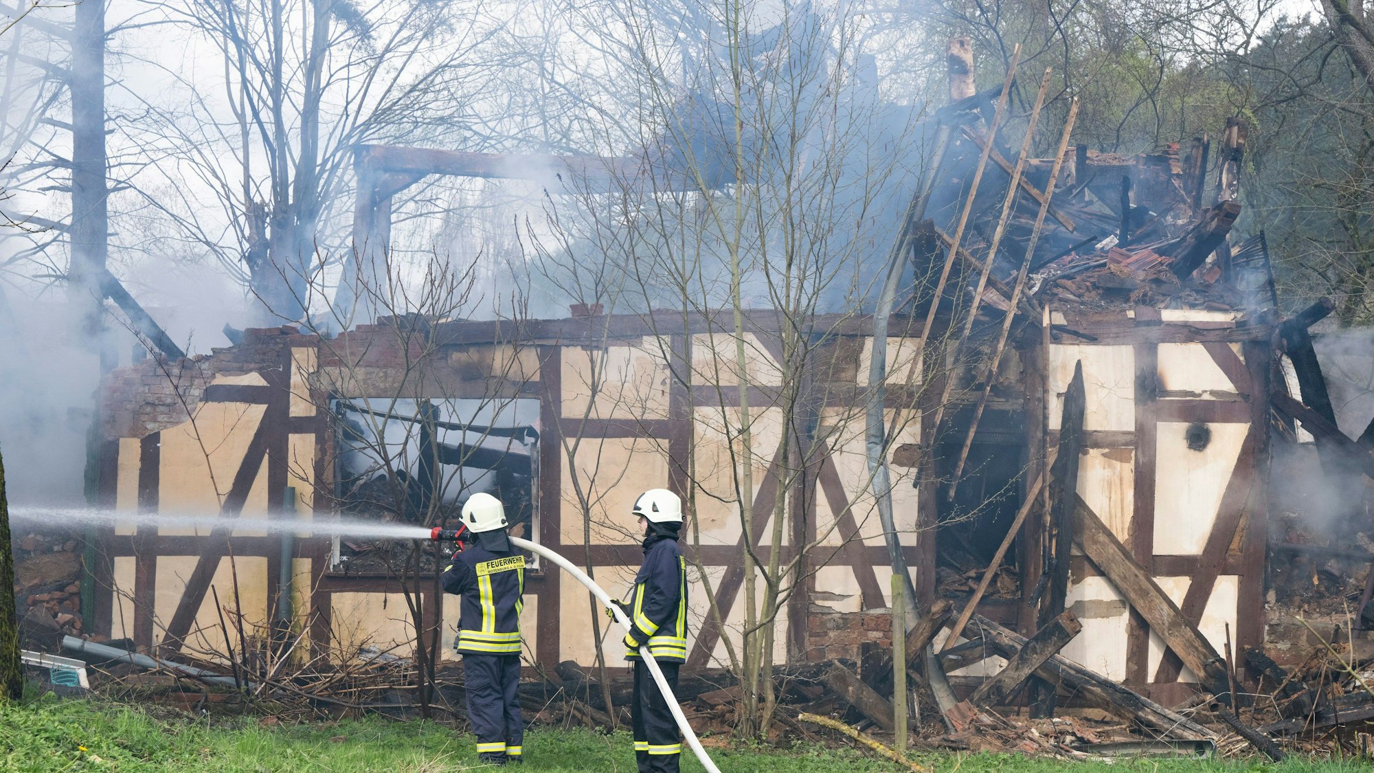 Feuerwehrleute löschen in Wüstefeld bei Rotenburg die noch rauchenden Trümmer des ehemaligen Hofes des «Kannibalen von Rotenburg».