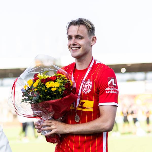 Jacob Steen Christensen steht mit einem Blumenstrauß auf dem Spielfeld.