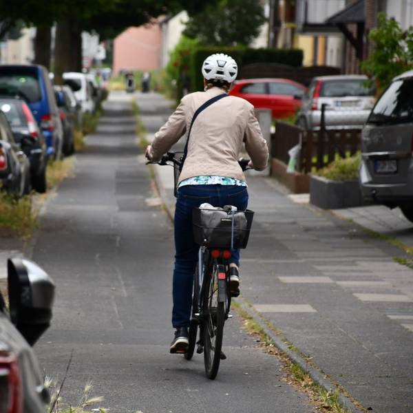 Eine Radlerin fährt mit ihrem Rad.