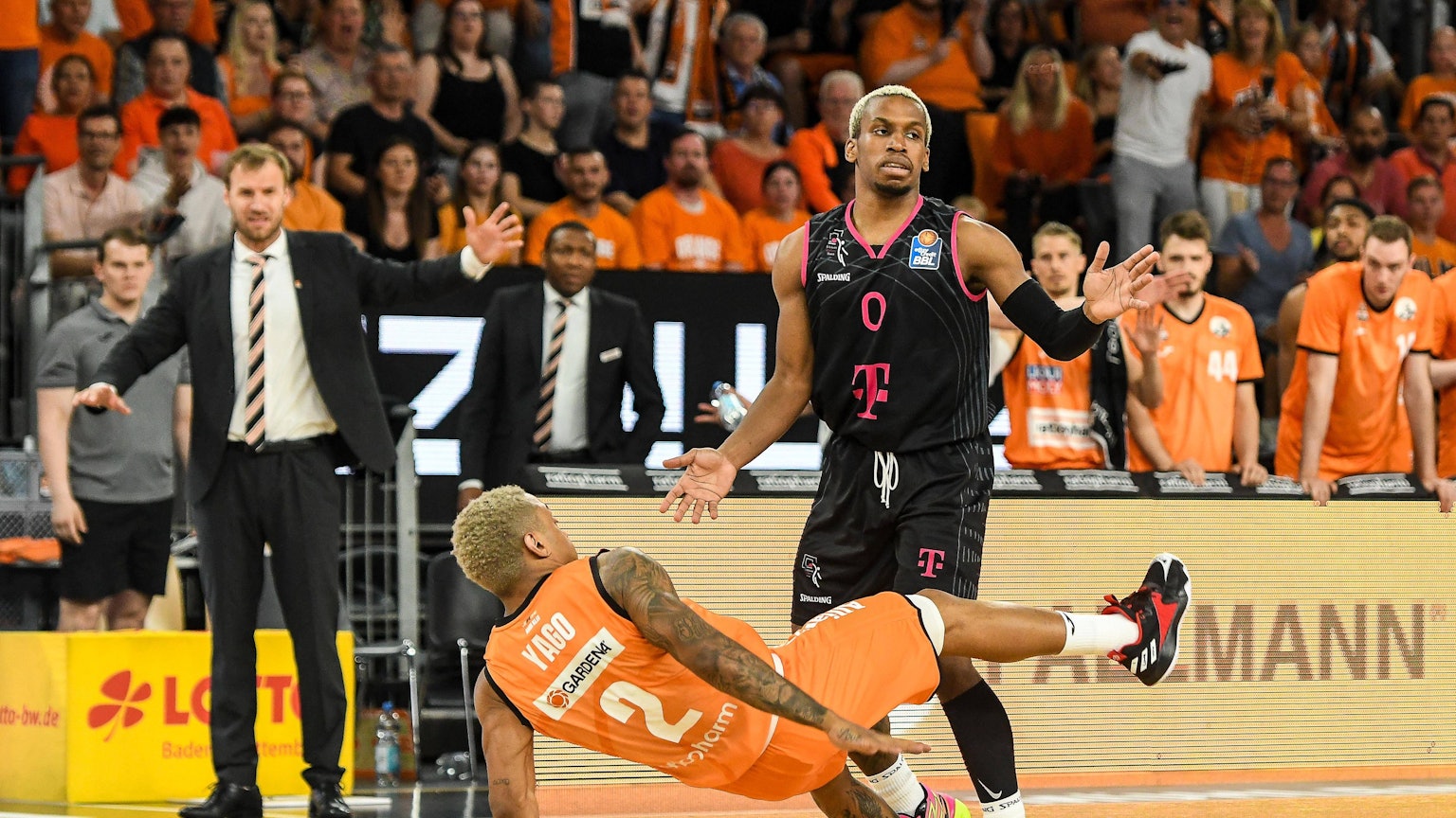 Yago Mateus dos Santos geht zu Boden, nachdem TJ Shots II auf ihn aufeglaufen ist. Im Hintergrund steht Ulms Trainer Anton Gavel.