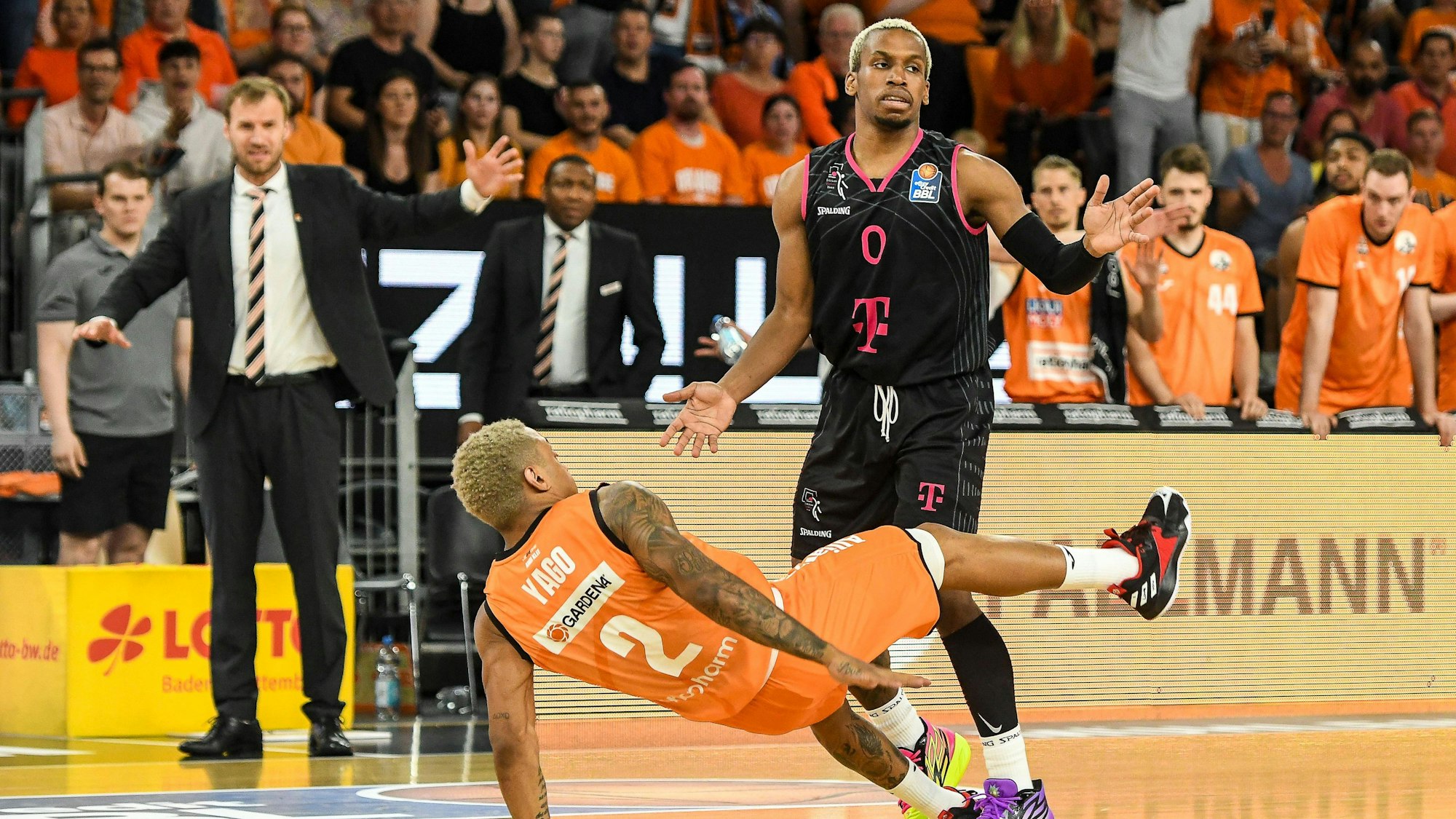 Yago Mateus dos Santos geht zu Boden, nachdem TJ Shots II auf ihn aufeglaufen ist. Im Hintergrund steht Ulms Trainer Anton Gavel.