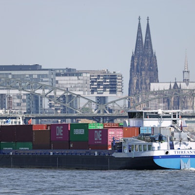 Ein Binnenschiff, mit Containern beladen, fährt in Köln vor dem Dom (r) und den Kranhäusern (l) über den Rhein.