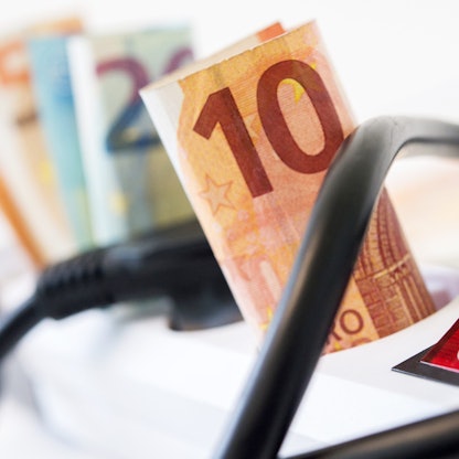 Geldscheine stecken eingerollt in einer Steckdosenleiste.