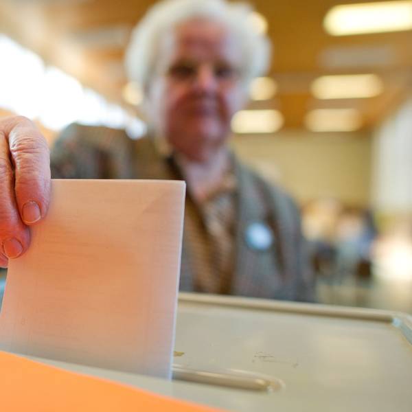 Eine Wählerin wirft ihren Stimmzettel in eine Wahlurne.