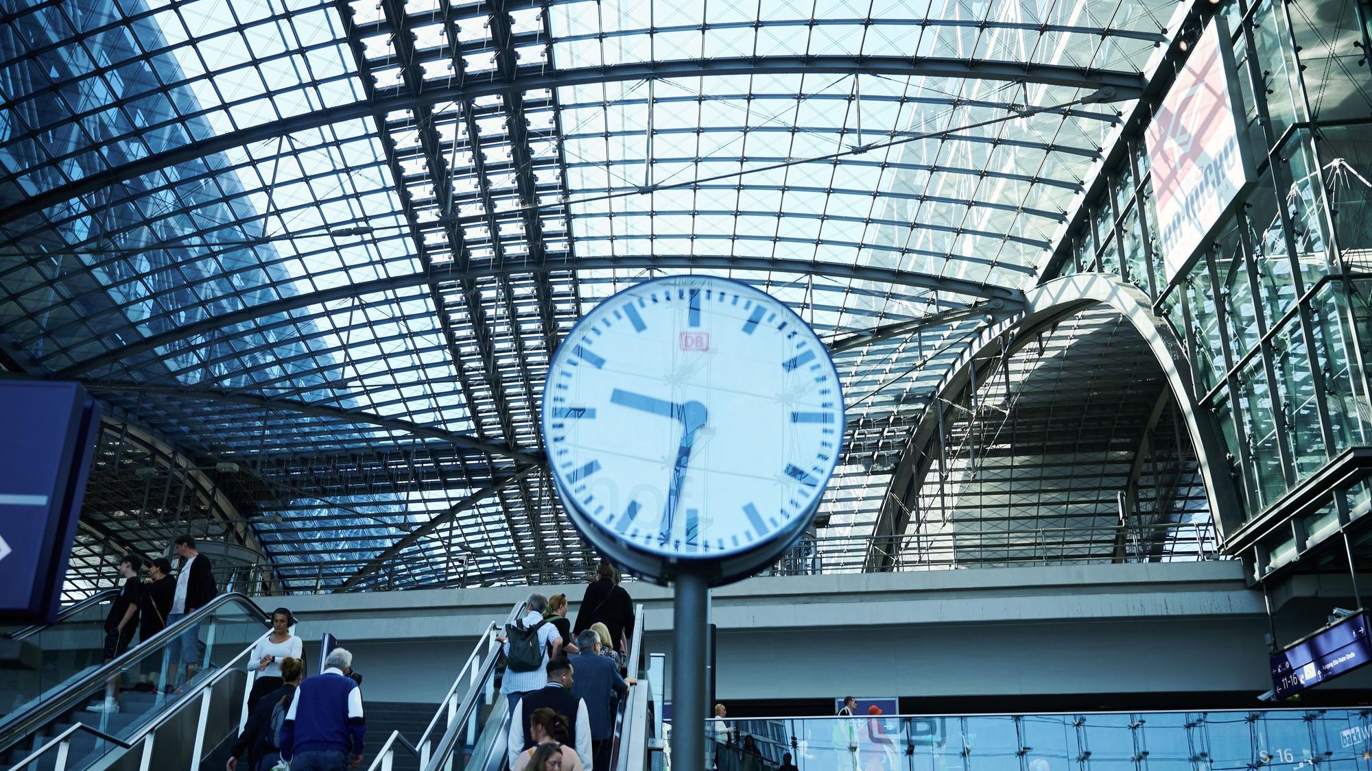 Eine Uhr hängt in der Eingangshalle des Hauptbahnhofes Berlin.