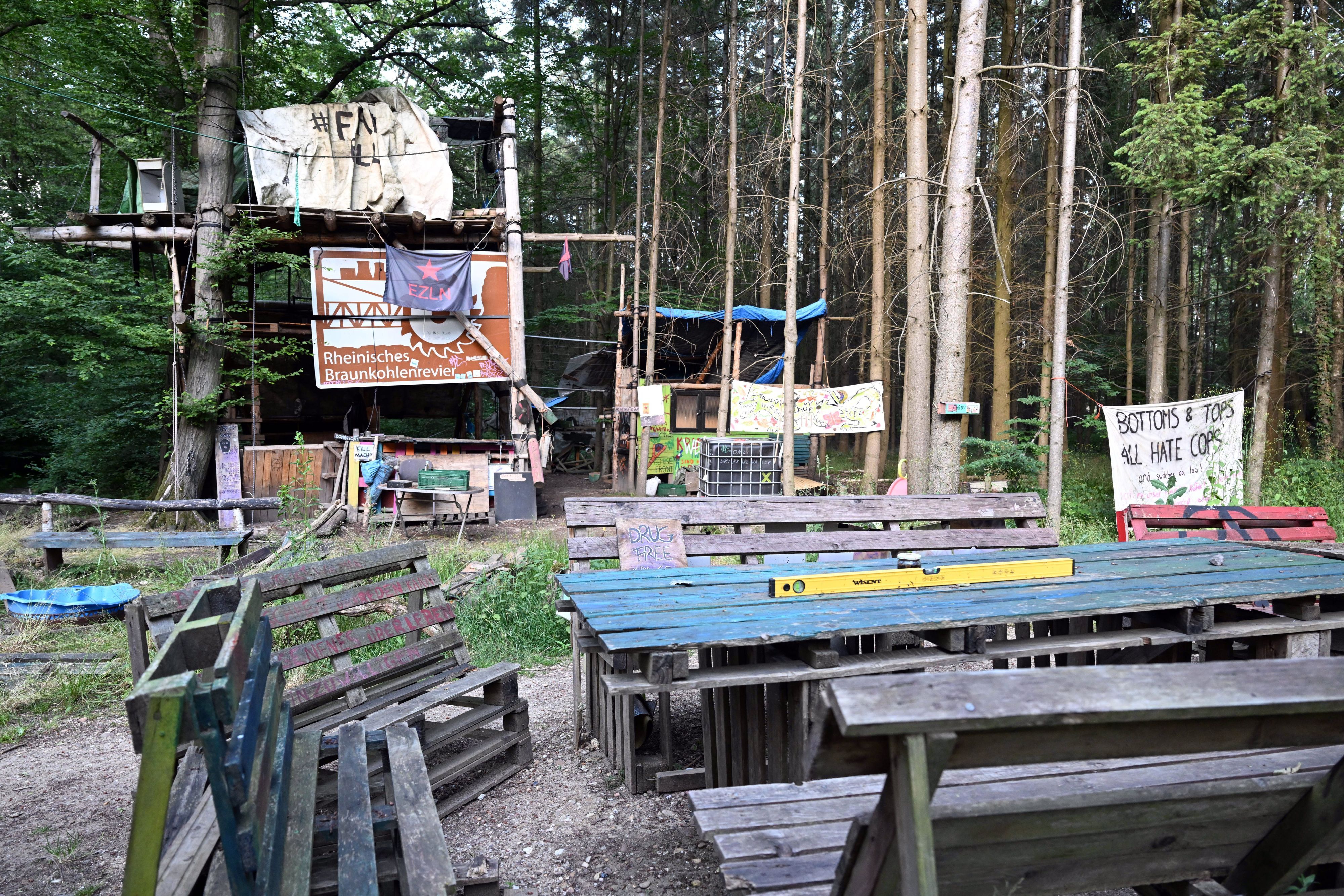 Verlassene Baumhäuser stehen im Hambacher Forst hinter leeren Tischen und Bänken. Mit der Räumung des Hambacher Forsts im Jahr 2018 beschäftigt sich am Freitag (16.06.2023) das nordrhein-westfälische Oberverwaltungsgericht in Münster.