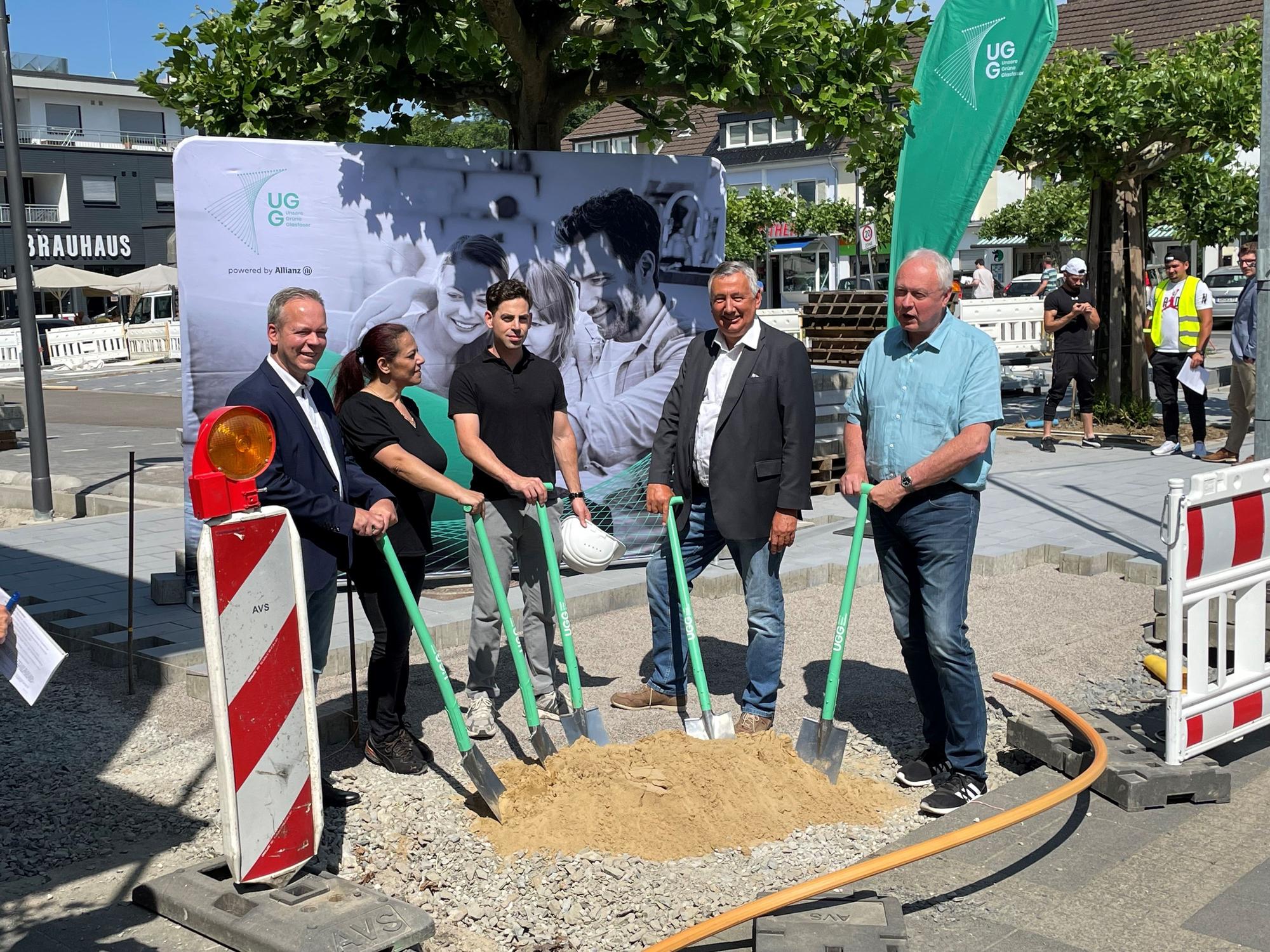 Auf dem Bahnhofplatz in Engelskirchen stehen Bürgermeister Dr. Gero Karthaus, Stefan Syrek, Klaus Grootens, Thamos Avlonitis von der Firma Insyte und Maria Sculco von „Unsere Grüne Glasfaser“.
