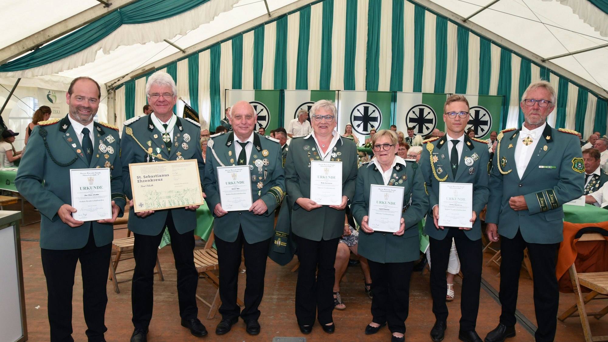 Es sind mehrere Menschen mit Urkunden zu sehen.