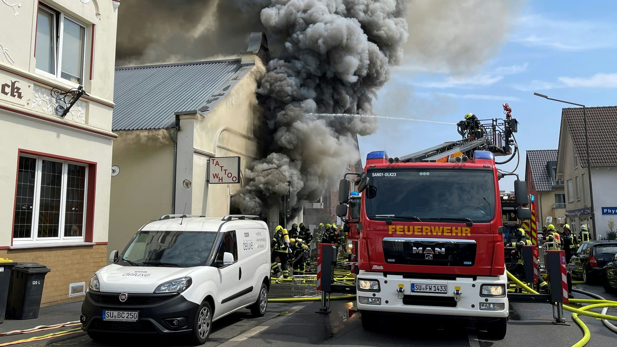 Aus einem Gebäude quillt dichter, dunkler Rauch.