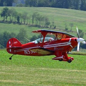 Ein Doppeldecker fliegt über die Piste auf dem Dümpel.