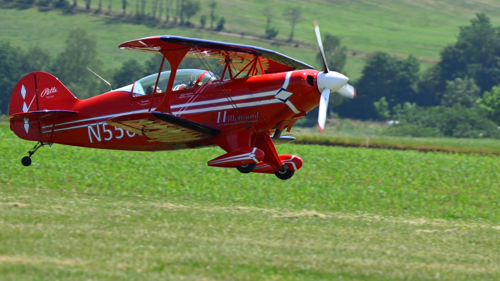 Ein Doppeldecker fliegt über die Piste auf dem Dümpel.