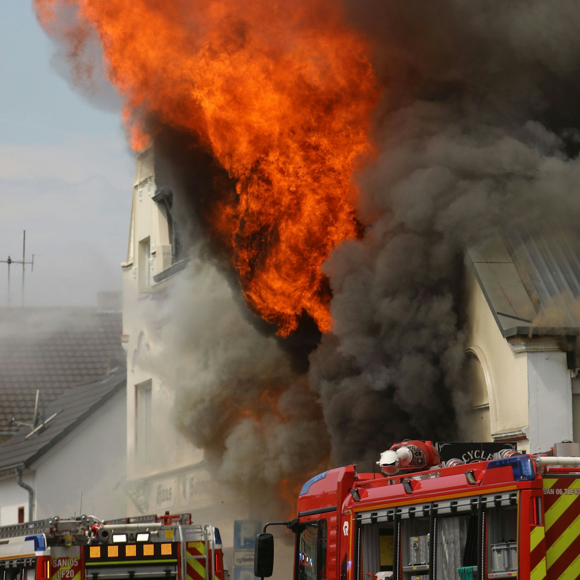 dpatopbilder - 18.06.2023, Nordrhein-Westfalen, St. Augustin: Flammen schlagen aus einem Dach. Ein Motorradladen ist in Sankt Augustin im Rhein-Sieg-Kreis in Brand geraten. Zahlreiche Einsatzkräfte sind am Sonntag ausgerückt. Foto: Ralf Klodt/dpa +++ dpa-Bildfunk +++