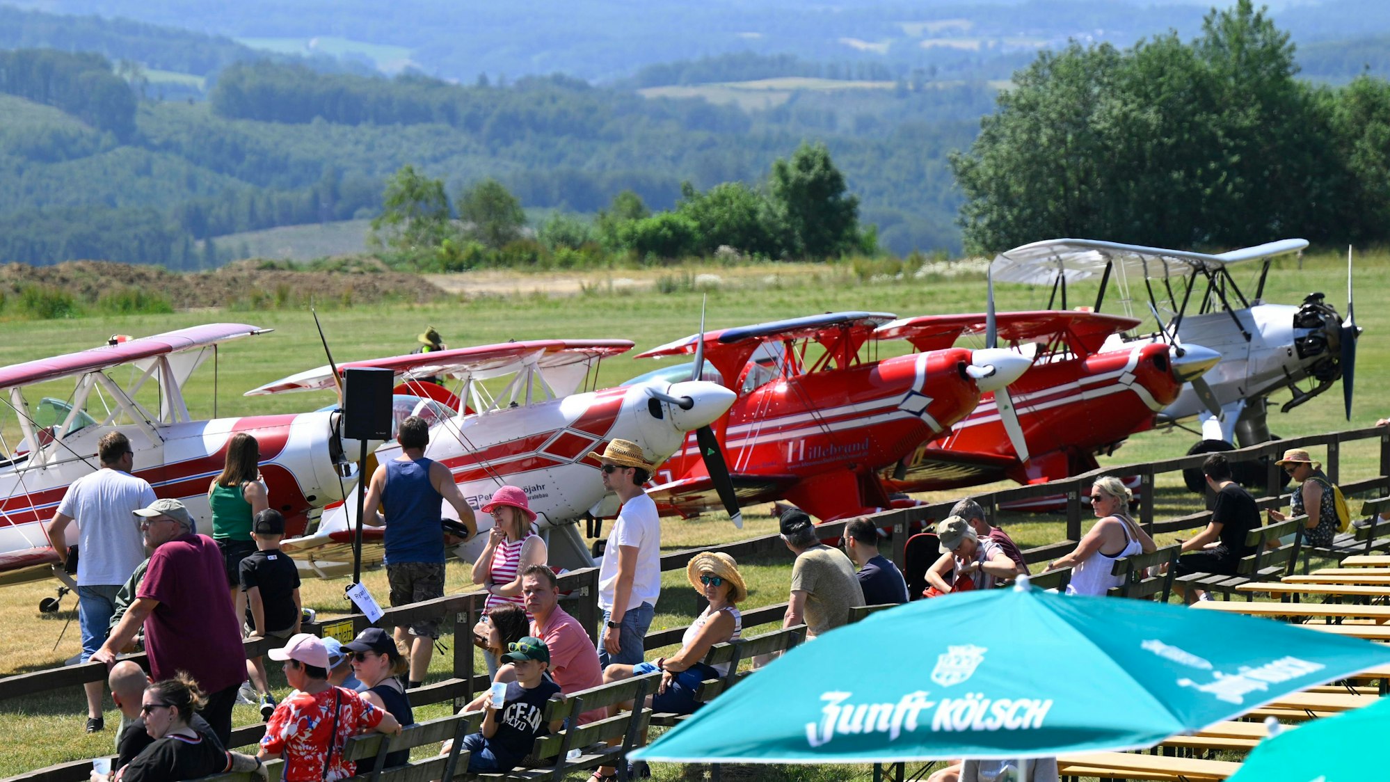 Besucher betrachten eine Reihe mit Flugzeugen.