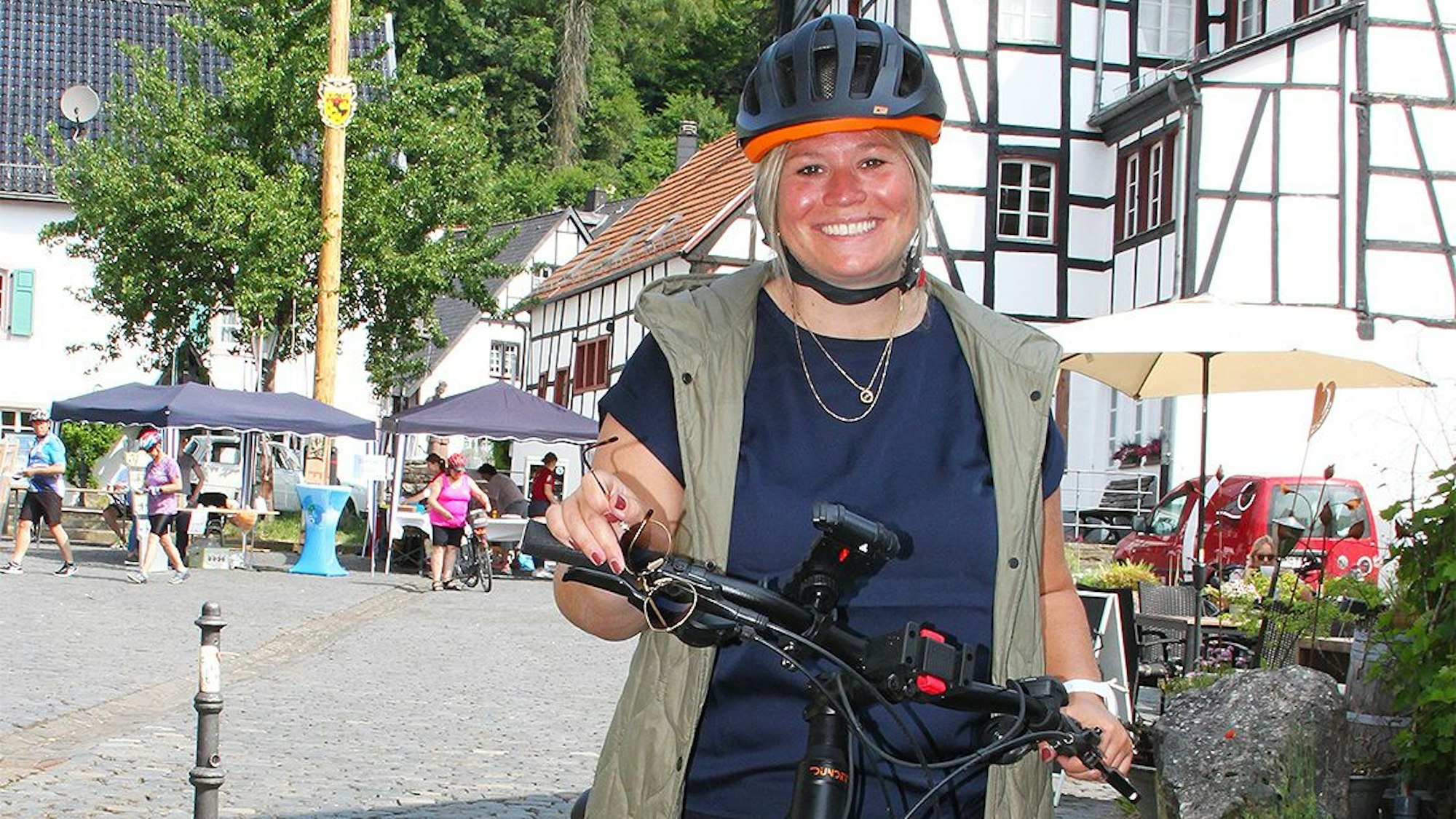 Das Bild zeigt die Blankenheimer Bürgermeisterin Jennifer Meuren. Sie trägt einen Fahrradhelm und fährt ein E-Bike.