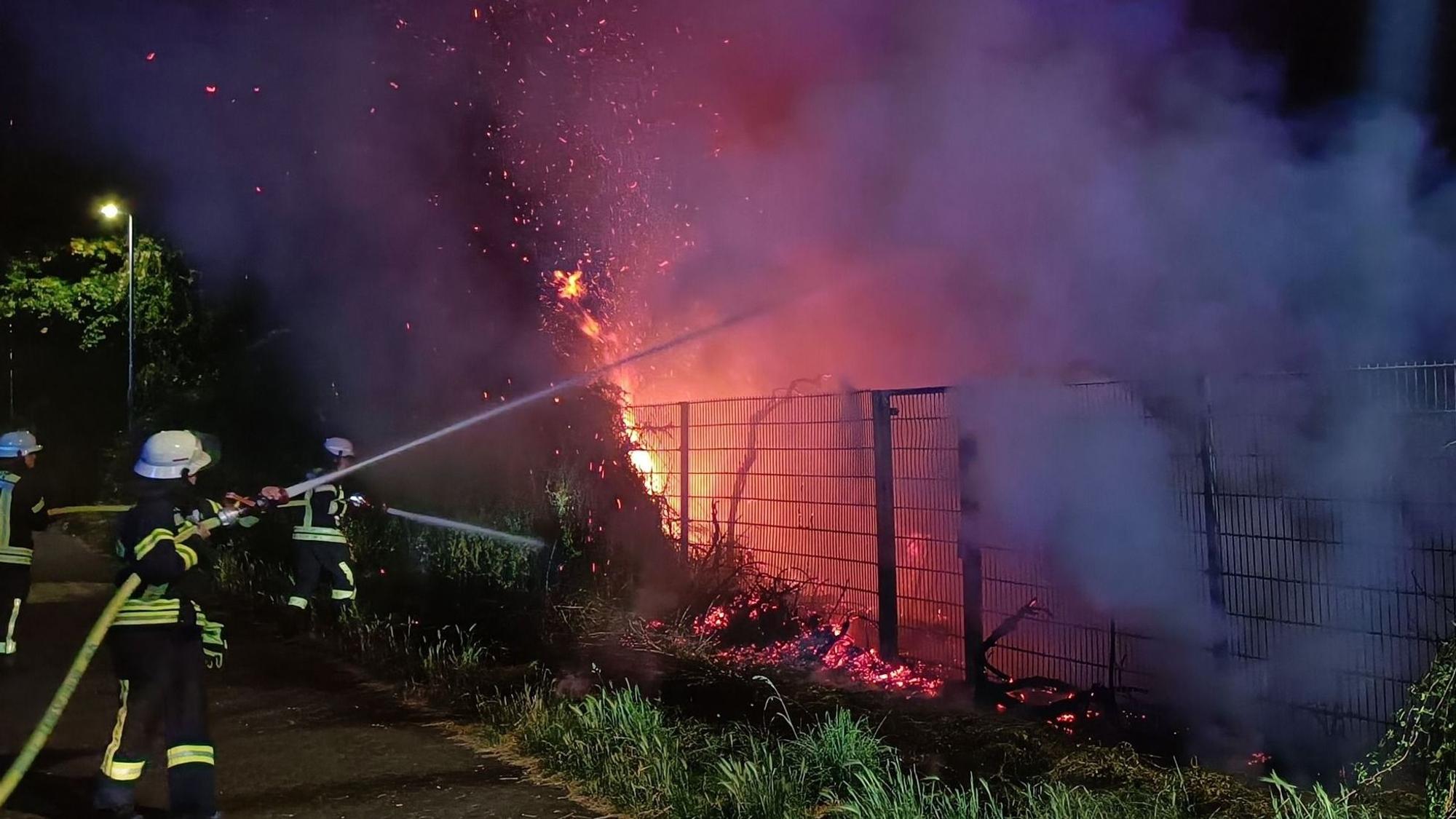 Drei Feuerwehrleute löschen ein Feuer in Kerpen.