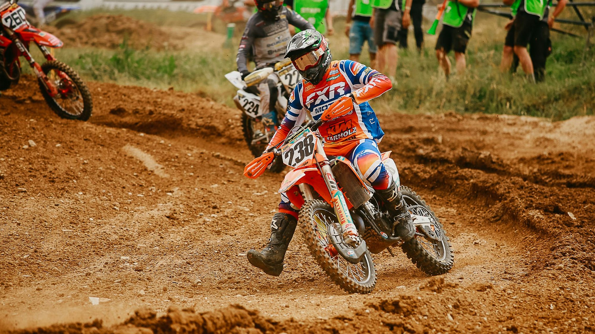 Ein Motocross-Fahrer fährt auf lehmigen Boden.