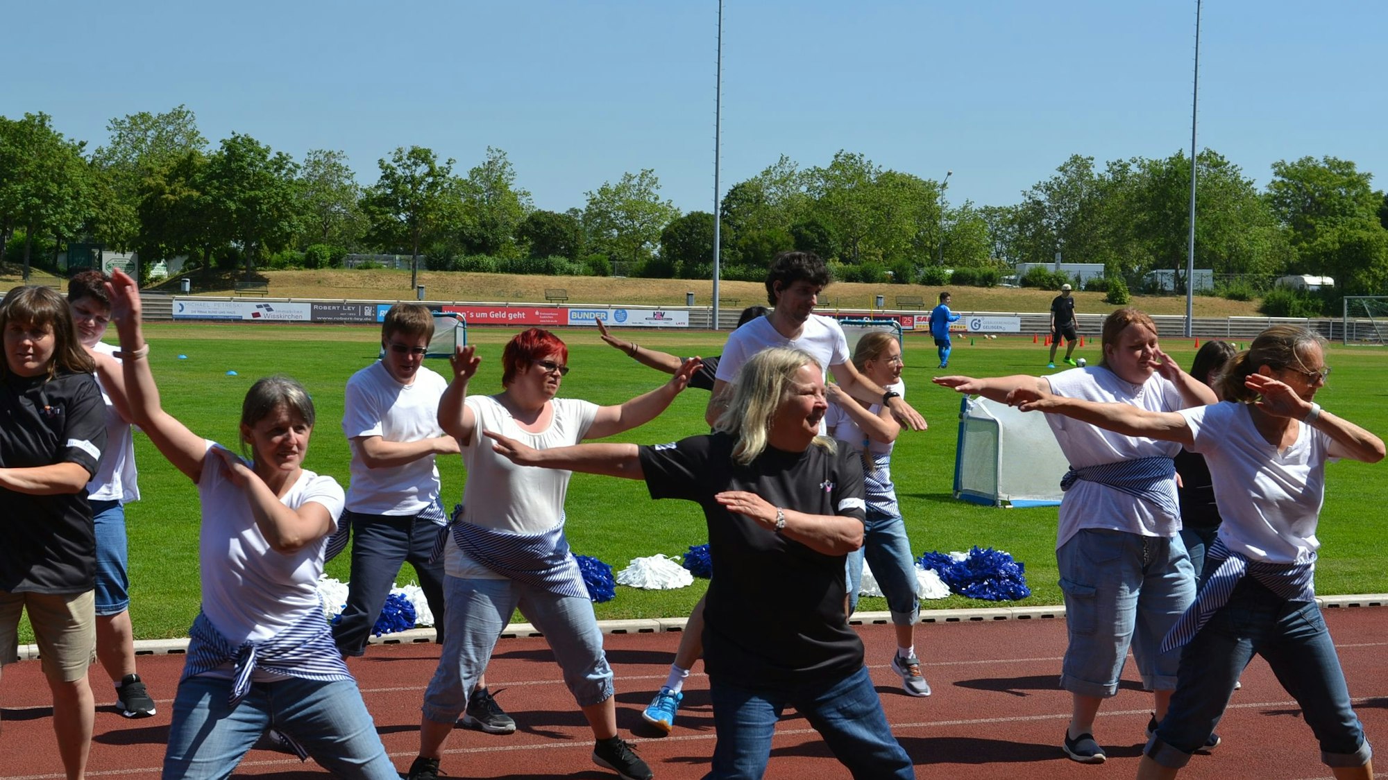 Eine Gruppe tanzt auf der Tartanbahn des Erftstadions.