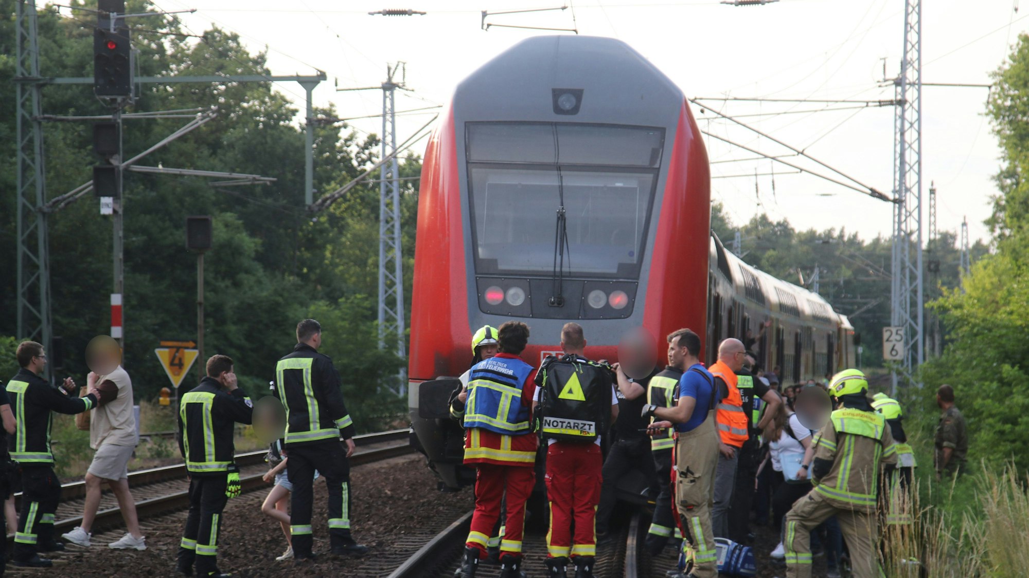 18.06.2023, Berlin: Menschen werden aus einem Zug evakuiert. Auf freier Strecke ist in Berlin in der Wuhlheide am Sonntagabend ein Regionalexpress wegen einer Fahrzeugstörung liegen geblieben. Der Zug musste evakuiert und später abgeschleppt werden.