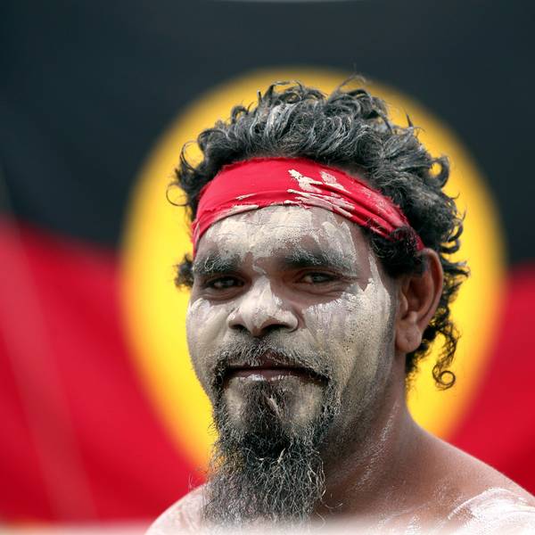 26. Januar 2018, Australien, Sydney: Stedman Sailor steht vor der Fahne der Aborigines, als er mit anderen Mitgliedern der indigenen Bevölkerung Australiens an einer Rauchzeremonie im Rahmen der Feierlichkeiten zum Australia Day teilnimmt.