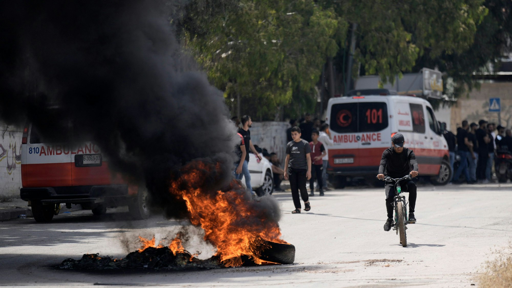 Nach Zusammenstößen zwischen israelischen Streitkräften und militanten Palästinensern liegen brennende Reifen auf der Straße.