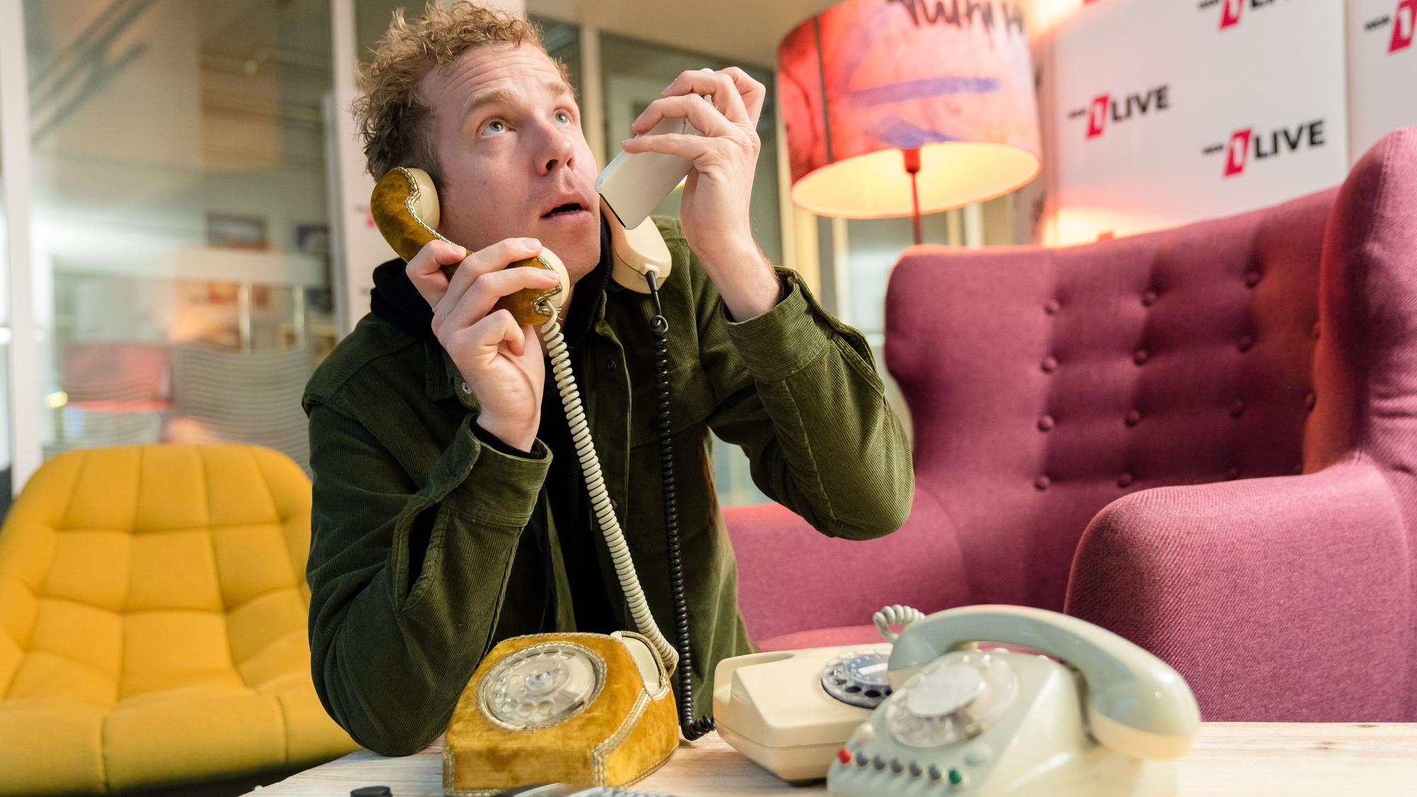 Daniel „Danger“ Schlipf posiert mit mehreren Telefonen.