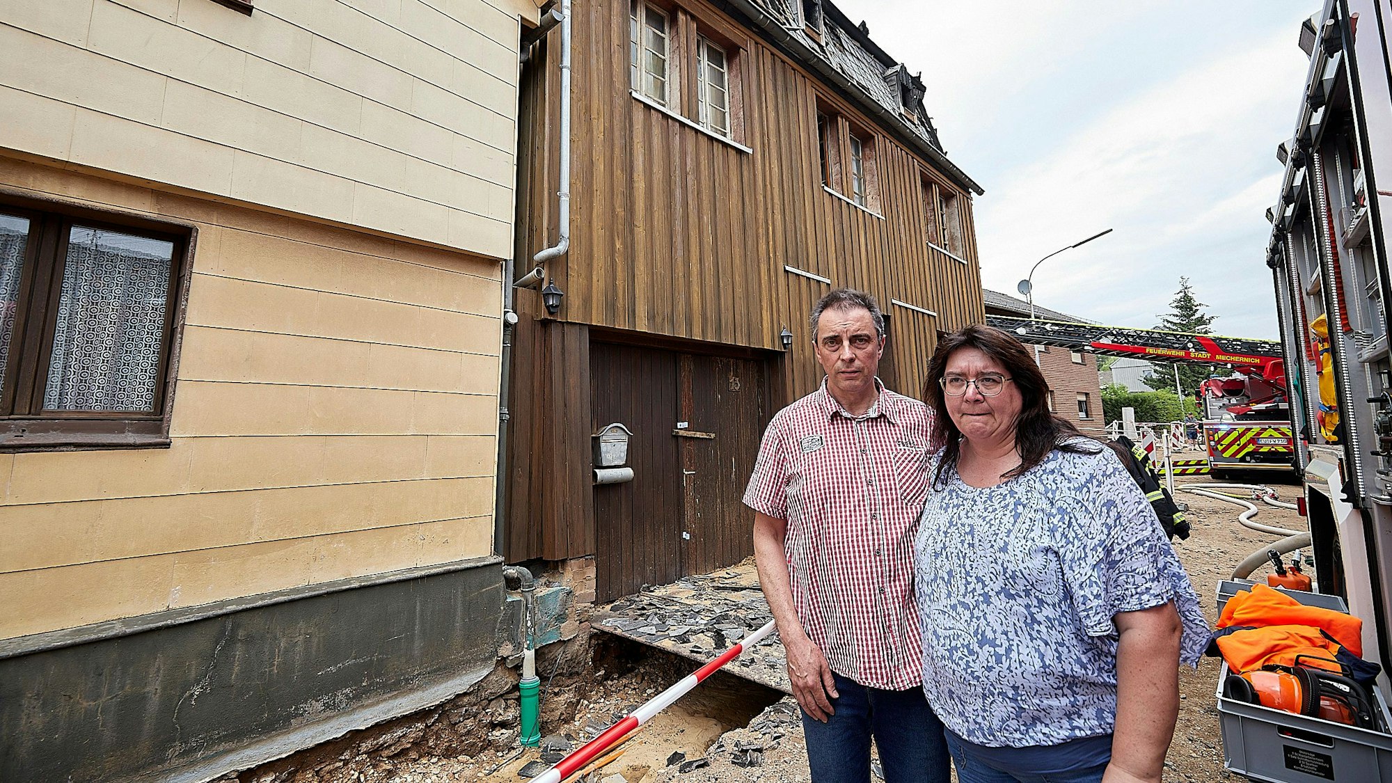 Das Bild zeigt Harald Maria Liers und seine Frau Sabine vor ihrem ausgebrannten Haus in Weyer.