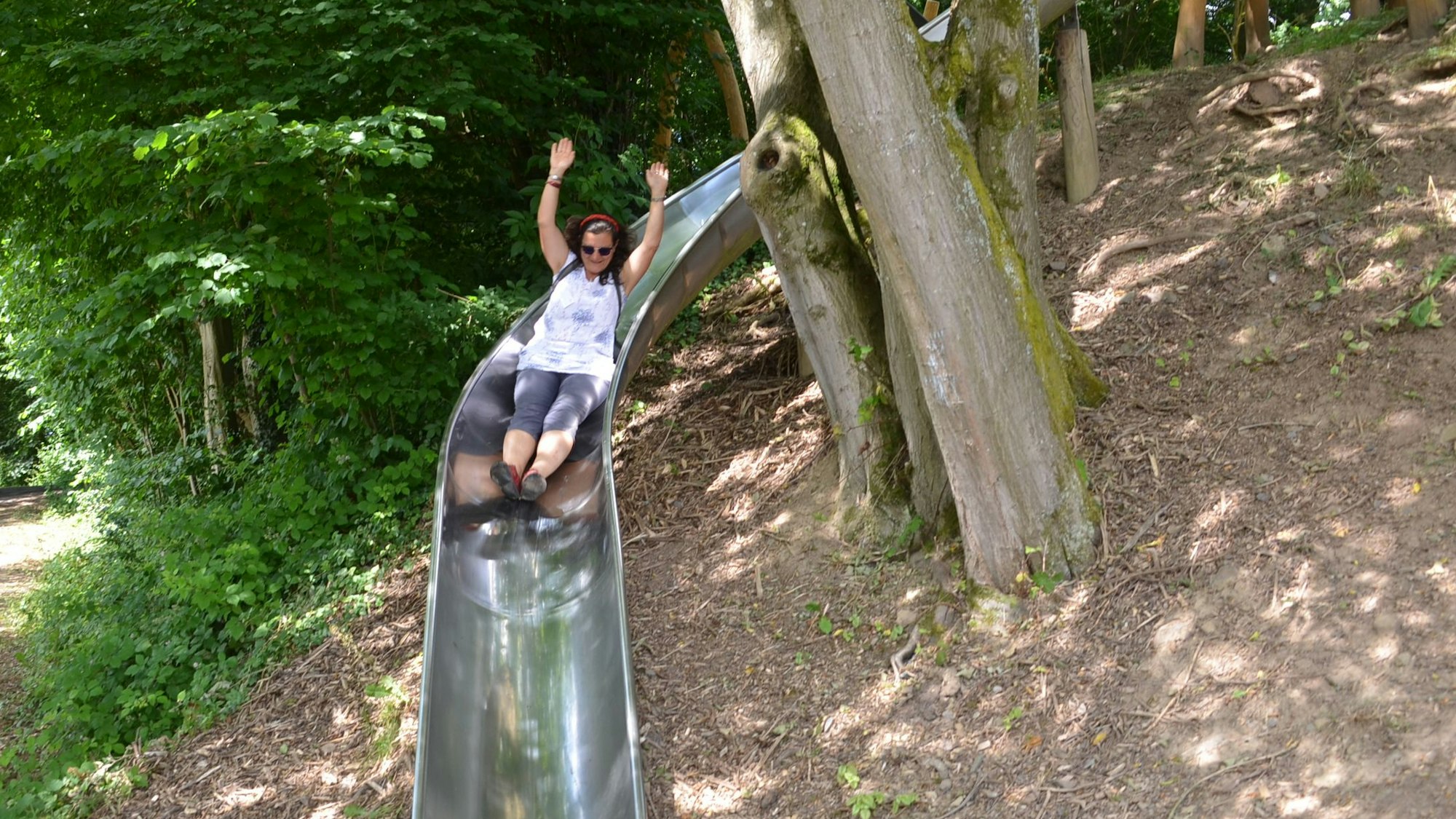 Eine der Jurorinnen wagt sich auf die Rutsche des Vorzeigespielplatzes im Grünen.