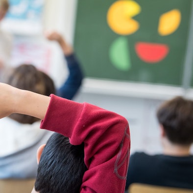 Ein Schüler meldet sich während einer Mathestunde.