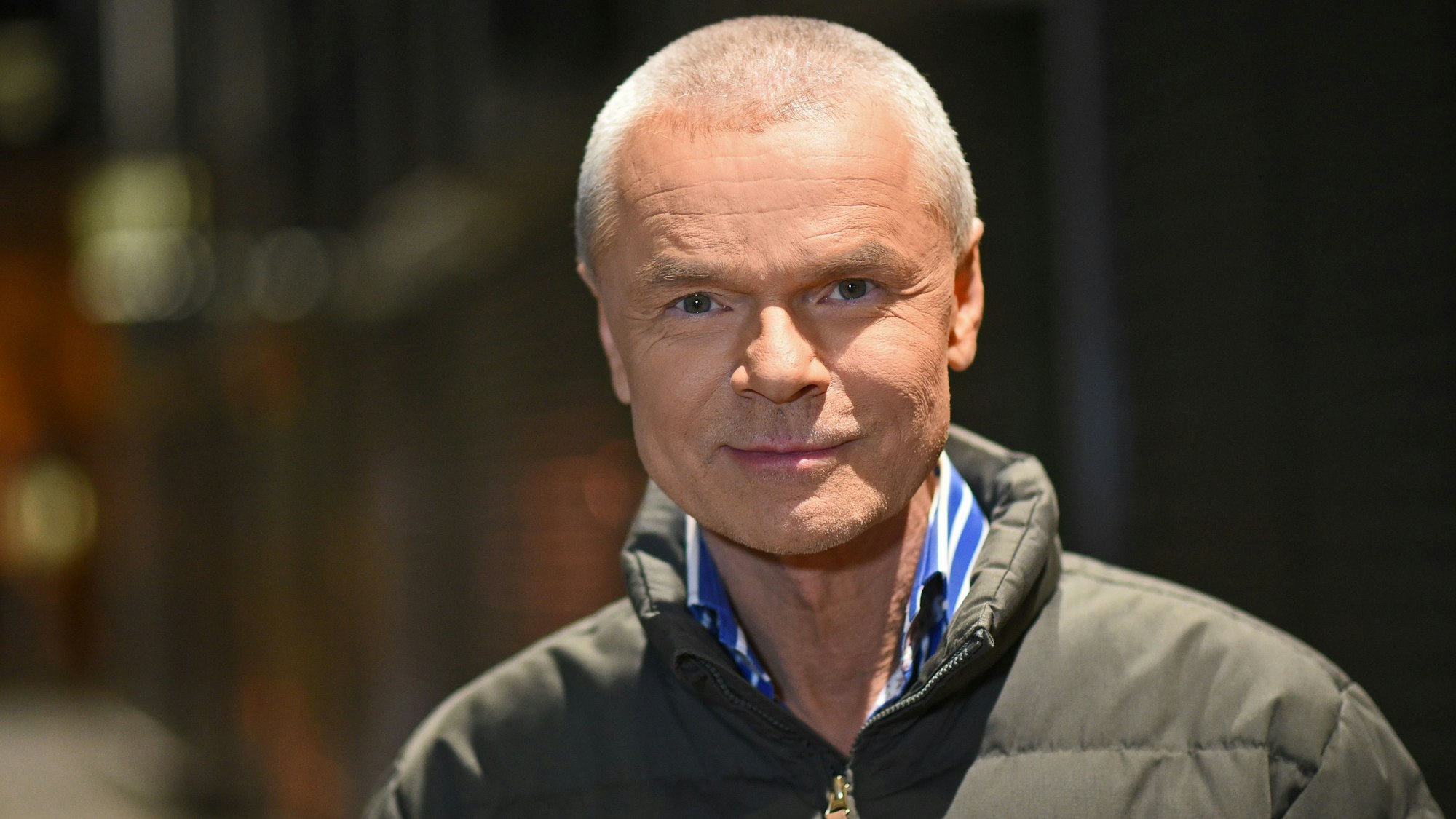 Der Moderator Jürgen Domian schaut in die Kamera und lächelt sanft.
